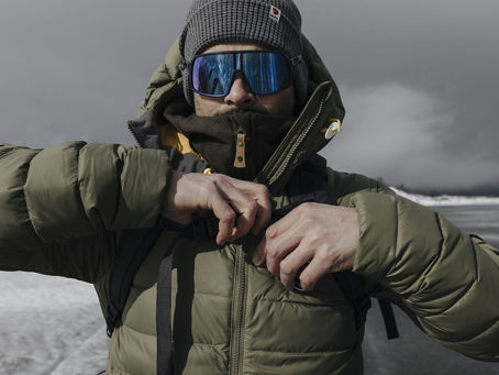 a man wearing green jackets in an outdoor location