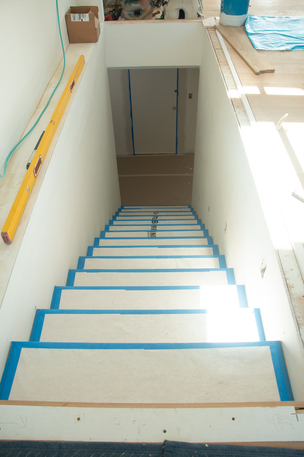 Staircase under construction with protective coverings.