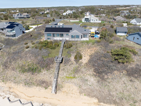 Aerial view of a coastal house on a hill.