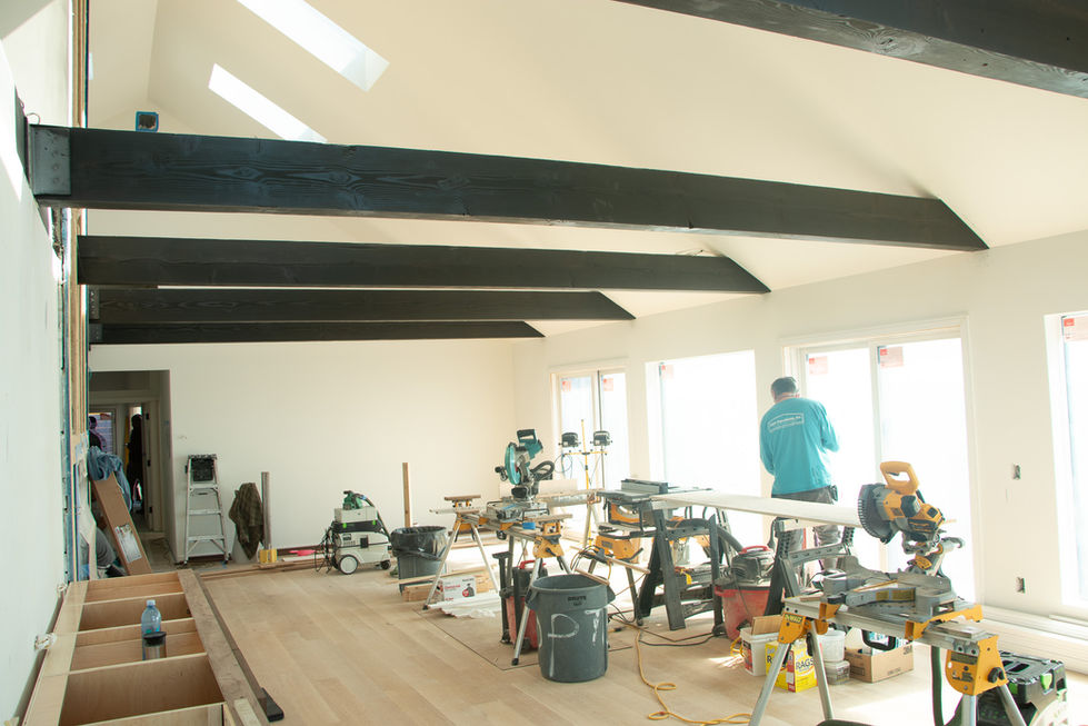 Room under renovation with tools and workers present.