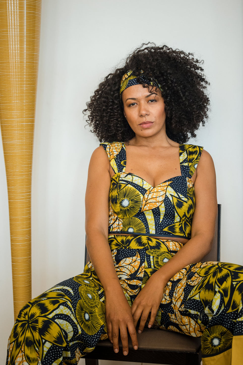 african printed crop top with a wid-leg trousers with an african print and a yellow big stripe at the hem