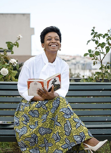 CEO and designer, Roselyn Silva creator of Roselyn Silva Brand. African-inspired Luxury Brand dressed in one of her skirt with a green african print and a white blouse