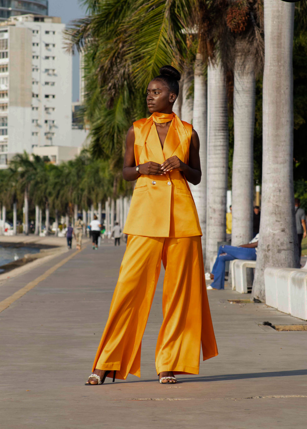 A tailored blazer vest with leg-wide pants in silk orange.
