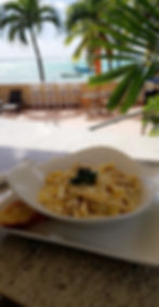 Creamy pasta with tropical beach view in Barbados