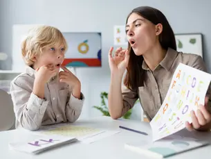Một người phụ nữ và một trẻ nhỏ đang luyện phát âm bằng bảng chữ cái đầy màu sắc trong một căn phòng sáng sủa, cả hai đều tập trung và hứng thú với hoạt động học. Đây là một hoạt động hỗ trợ phát triển ngôn ngữ cho trẻ mắc ADHD trẻ em.