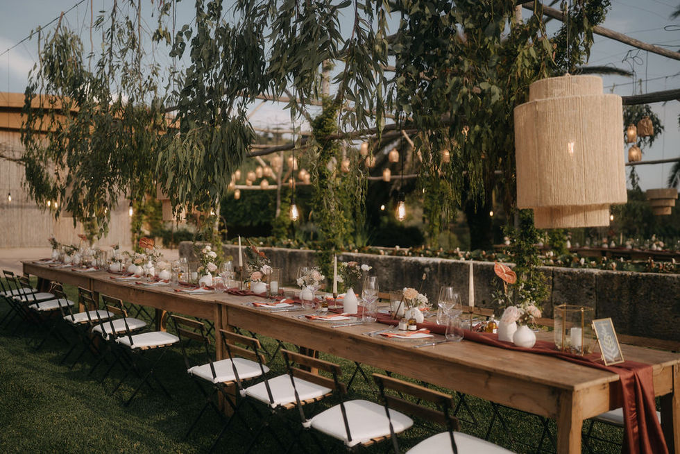 Simple and elegant imperial table with rattan lamps, eucaliptus leaves and vintage lights hanging on top of the table.