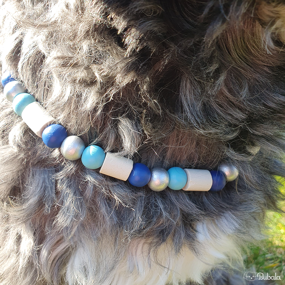 Thumbnail: Hundehalsband mit EM-Keramik-Perlen, Dunkelblau-Töne, mit Anker-Anhänger, an schwarz-weißem Hund im Grünen, Nahaufnahme