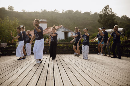 A group of people practicing martial arts on a wooden deck 
