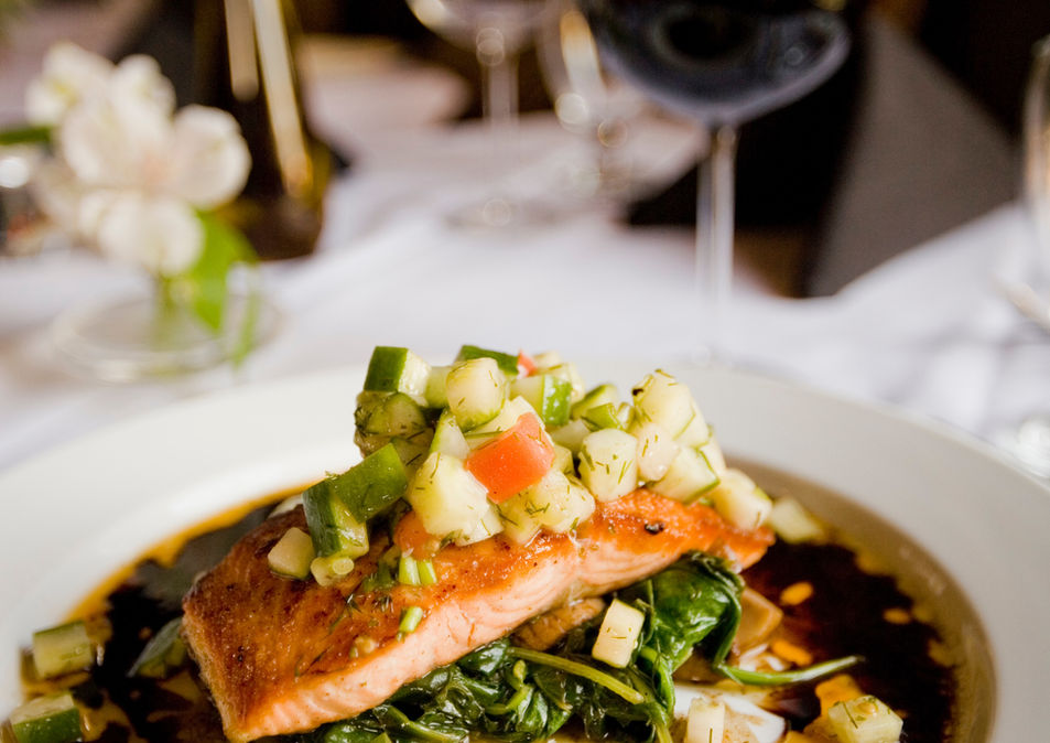 Salmon with diced vegetable topping on spinach.