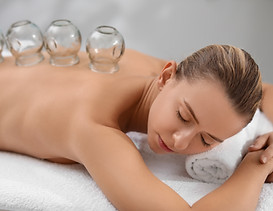 Cupping therapy. Woman with glass cups on massage couch in spa salon.jpg