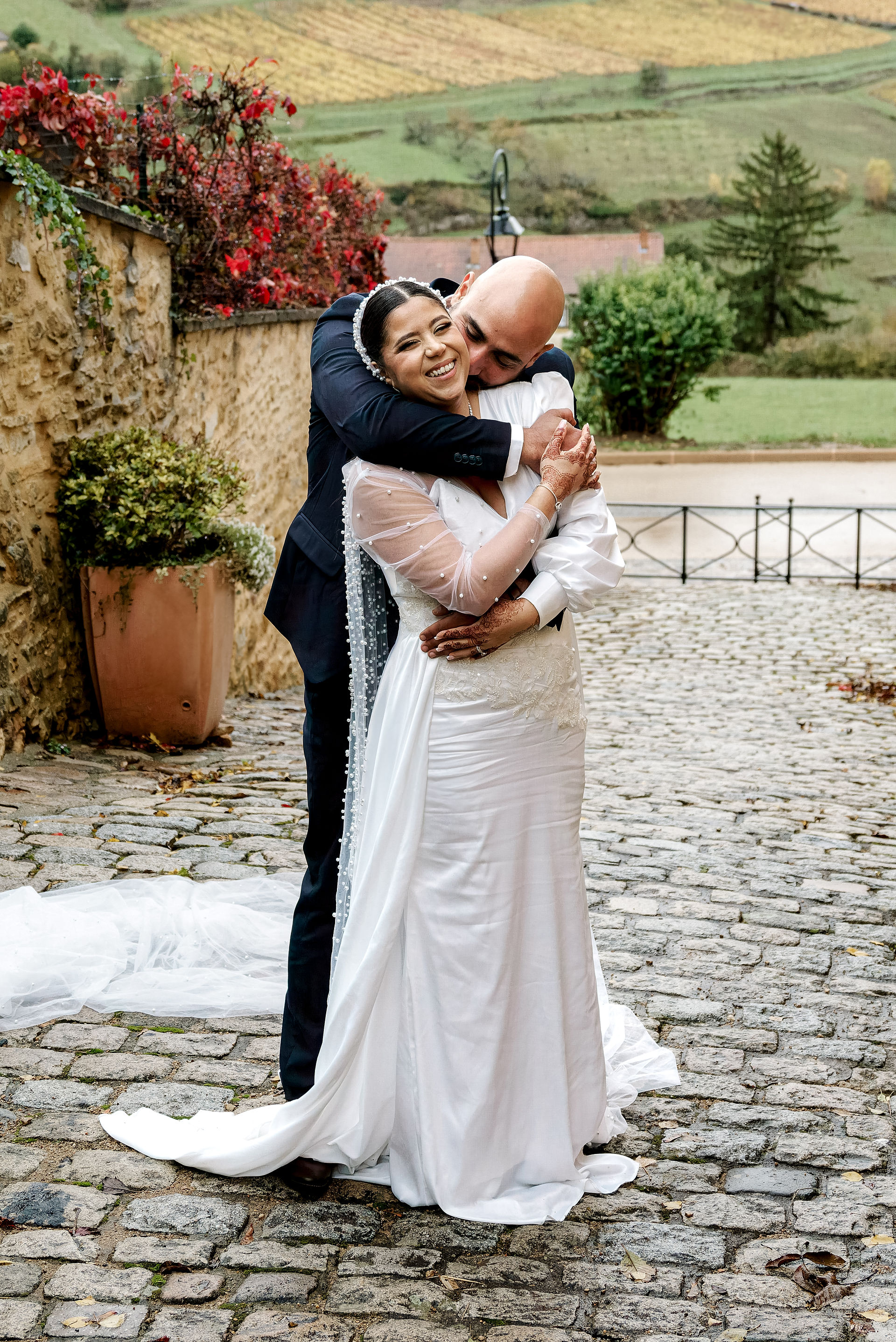 Photo de mariage de Rania et Jordan se prenant dans les bras, souriants et complices, après leur union civile. Photographie capturée par Colombe Photographie, photographe de mariage à Lyon.