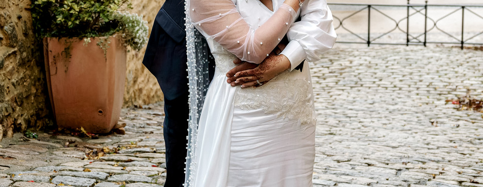 Photo de mariage de Rania et Jordan se prenant dans les bras, souriants et complices, après leur union civile. Photographie capturée par Colombe Photographie, photographe de mariage à Lyon.