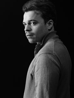 Portrait artistique en clair-obscur, plan américain et angle trois quarts. Une expression pensée et introspective, jouant avec la lumière et les ombres pour un rendu intense et captivant. Sur fond noir.