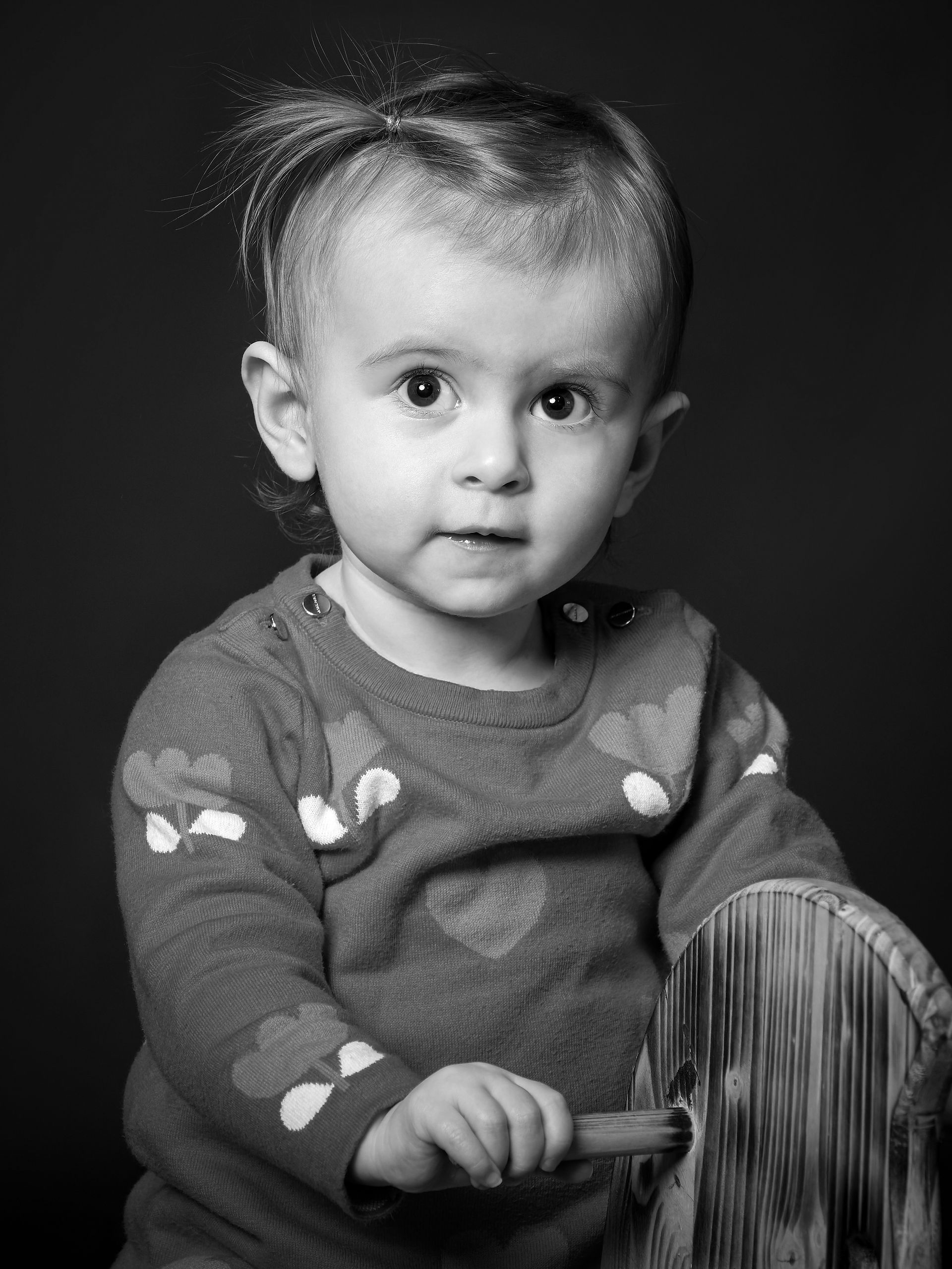 Portrait d’enfant en noir et blanc réalisé au Studio Colombe Photographie à Gentilly, en région parisienne. Cette image met en valeur le regard expressif d’une petite fille dans un décor studio sobre et élégant. Le studio Colombe Photographie est spécialisé en portraits enfant et famille, proposant des séances naturelles, artistiques et intemporelles. Idéal pour une séance photo bébé ou enfant en studio à Gentilly ou partout en Île-de-France.