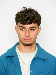 Portrait mannequin homme réalisé en studio sur fond bleu uniforme avec éclairage doux et naturel. Cette photo type polas met en valeur les traits du visage, l’expression neutre et la photogénie du modèle, idéale pour un book comédien ou mannequin professionnel. Parfait pour agences, castings et portfolios artistiques.