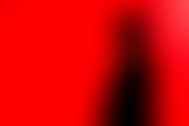 Portrait d’Armel en ombre chinoise sur fond rouge vif, réalisé en lumière contrôlée pendant sa soirée d’anniversaire. Photo artistique prise par Colombe Photographie à Gentilly, photographe d’événements et portraits créatifs en Île-de-France.