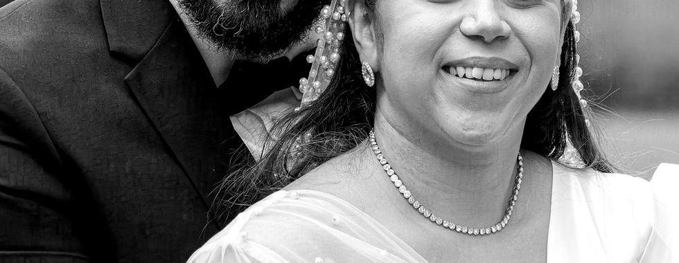 Portrait en noir et blanc de Rania et Jordan, jeunes mariés souriants après leur cérémonie civile. Photographie de mariage réalisée par Colombe Photographie à Lyon.