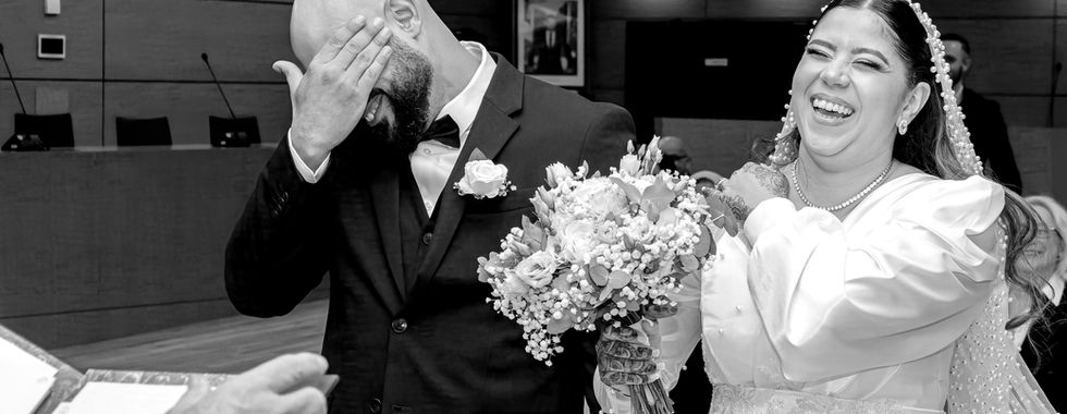 Photo en noir et blanc des mariés riant ensemble lors de leur mariage civil à la mairie de Rillieux-la-Pape. Instant spontané capturé par Colombe Photographie, photographe de mariage à Lyon et en région parisienne.