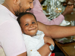 Photo d’un bébé dans les bras de son père pendant un anniversaire à Issy-les-Moulineaux. Image familiale capturée par un photographe anniversaire à Issy-les-Moulineaux. Studio photo basé à Gentilly, Île-de-France.