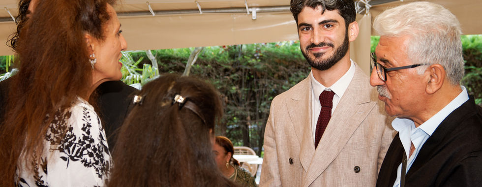 Invités et marié échangeant sous le chapiteau lors de la réception du mariage kurde-tunisien d’Omer et Syrine, scène conviviale capturée par Colombe Photographie à Saint-Gratien.