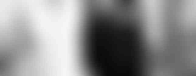 Photo en noir et blanc du mariage civil de Julie et Raphaël à Morsang-sur-Orge, capturant la sortie des mariés accompagnés de leur fils. La mariée, rayonnante, rit aux éclats tandis que le couple avance main dans la main. Une image vivante et pleine d’émotion, signée Studio Colombe Photographie, photographe de mariage à Gentilly et en région parisienne.