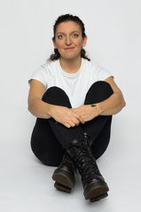 Pola de Cécile Aknin, assise en plein pied face caméra, réalisé en studio sur fond blanc. Une photo naturelle et épurée pour répondre aux exigences des agences et des directeurs de casting.