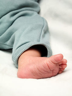 Gros plan sur le petit pied de Benjamin, emmitouflé dans un vêtement vert d’eau. Les plis délicats de sa peau évoquent toute la fragilité et la tendresse des premiers jours. Photo naissance réalisée au studio Colombe Photographie à Gentilly. Photographe naissance et bébé à Paris, spécialisée dans les détails poétiques et les instants doux du tout début de vie.