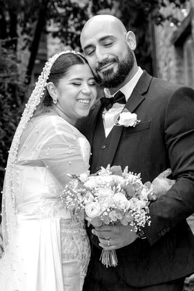 Photo de mariage en noir et blanc de Rania et Jordan partageant un moment complice, bouquet à la main. Image capturée par Colombe Photographie, photographe de mariage à Lyon.