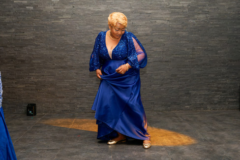 Photo d’une invitée vêtue de bleu en pleine danse sur la piste, pendant la soirée d’anniversaire surprise des 50 ans d’Armel. Reportage réalisé par Colombe Photographie à Gentilly.