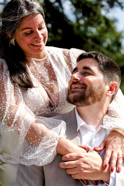 Photographie de couple d’Élodie et Damien à Palaiseau : les mariés partagent un regard complice et amoureux lors de leur mariage civil. Reportage réalisé par Henock, photographe partenaire du Studio Colombe Photographie, spécialisé dans les mariages en Essonne et en région parisienne.