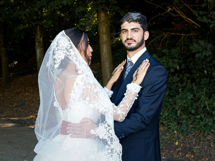 Mariée posant ses mains sur le torse de son époux Omer lors de leur séance photo de mariage à Écouen, instant intime et plein de douceur capturé par Colombe Photographie.