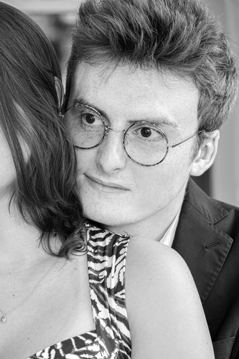 Portrait en noir et blanc de Thomas, photographié en gros plan, le visage appuyé contre l’épaule de Julie, sa fiancée. Il porte des lunettes rondes et un costume sombre, tandis qu’on distingue la robe à motifs de Julie au premier plan. Ce cliché a été réalisé lors de leur demande en fiançailles au Pré Catelan à Paris. Photographe de couple et de mariage basée à Gentilly, je propose des séances intimistes et naturelles en région parisienne pour immortaliser les émotions vraies.