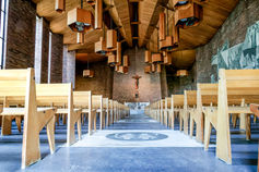 Intérieur de l’église Sainte Geneviève à Garges-lès-Gonesse, avec son architecture moderne et son autel. Reportage réalisé par une photographe baptême en Île-de-France pour immortaliser le baptême de Giulia.
