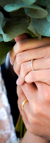 Photographie de détail du mariage civil de Julie et Raphaël à Morsang-sur-Orge, montrant les mains des mariés enlacées autour du bouquet de la mariée. Les alliances en or et diamant symbolisent leur union. Image pleine de poésie et d’émotion capturée par le Studio Colombe Photographie, photographe de mariage à Gentilly et en région parisienne.