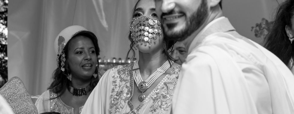 Mariés souriant en tenues traditionnelles kurdes durant la cérémonie du mariage kurde-tunisien d’Omer et Syrine, photo en noir et blanc capturée par Colombe Photographie à Saint-Gratien.
