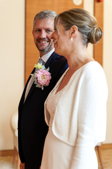 Portrait de Xavier et Camille lors de leur mariage civil à la mairie du 17e arrondissement de Paris, échangeant un regard complice pendant la cérémonie. Photographie réalisée par Henock pour le studio Colombe Photographie, photographe de mariage civil à Paris et en Île-de-France.
