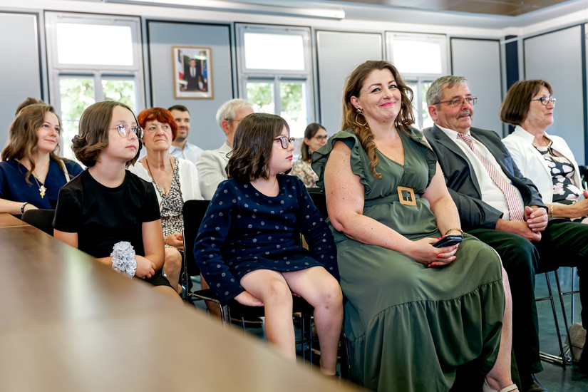 Photographie des invités lors du mariage civil d’Élodie et Damien à la mairie de Palaiseau. Famille et proches, souriants et attentifs, partagent l’émotion de ce moment unique. Reportage photo réalisé par Henock, photographe partenaire du Studio Colombe Photographie, spécialisé dans les mariages en Essonne et en Île-de-France.