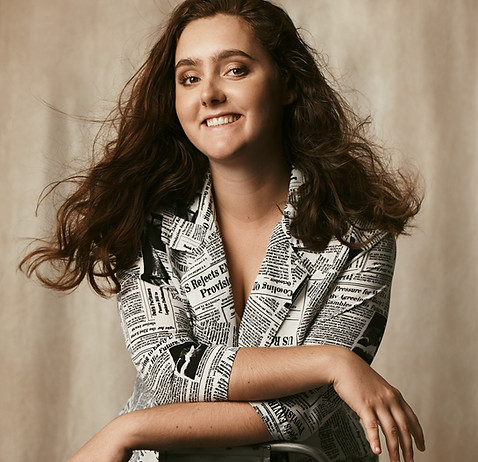Photo of Colombe Delons, sitting on a chair, smiling. Principal photographer at Colombe Photographie studio.