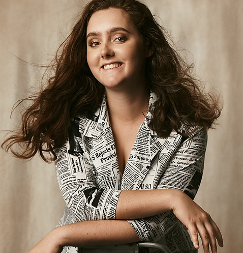 Photo of Colombe Delons, sitting on a chair, smiling. Principal photographer at Colombe Photographie studio.