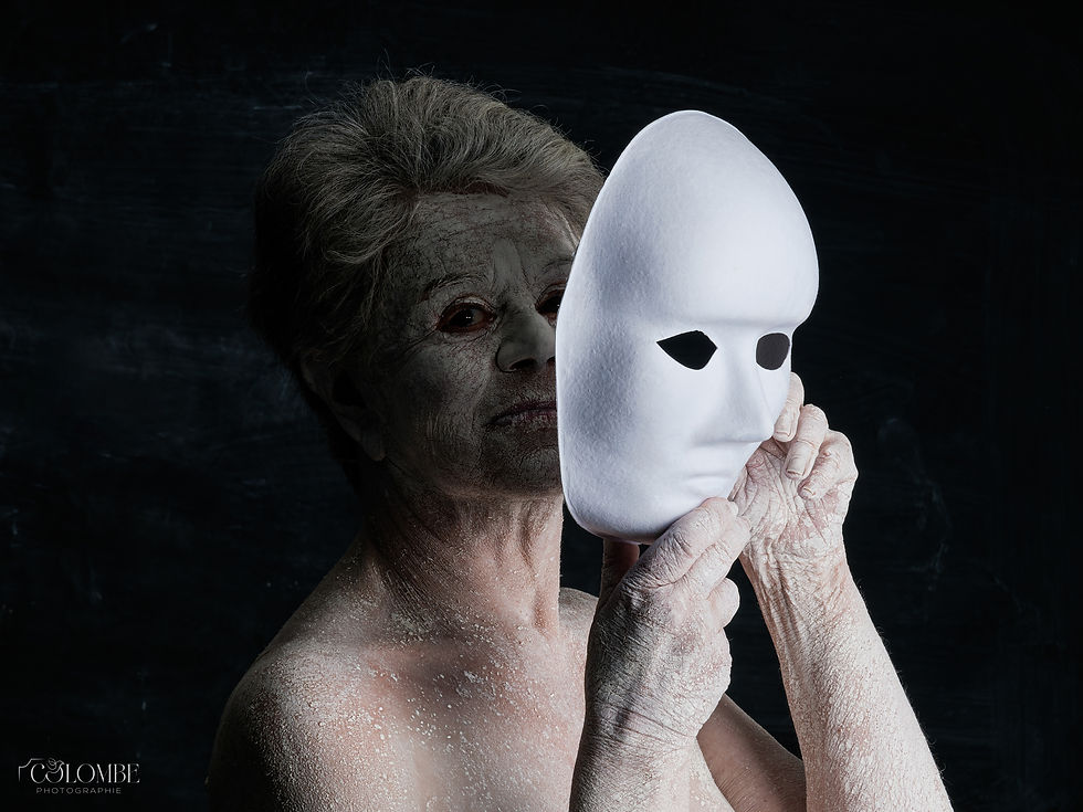 Photo artistique réalisée en studio, sur fond noir, dans le cadre du thème 'Corps d'Argile'. Le modèle, recouvert d'argile, tient un masque blanc devant son visage, créant une atmosphère mystique et introspective. Cette série explore les relations entre le corps humain, l'art et l'identité, mettant en avant l'usage de l'argile comme moyen d'expression corporelle et la symbolique du masque. Un travail photographique qui joue sur les contrastes visuels et l'interprétation personnelle.