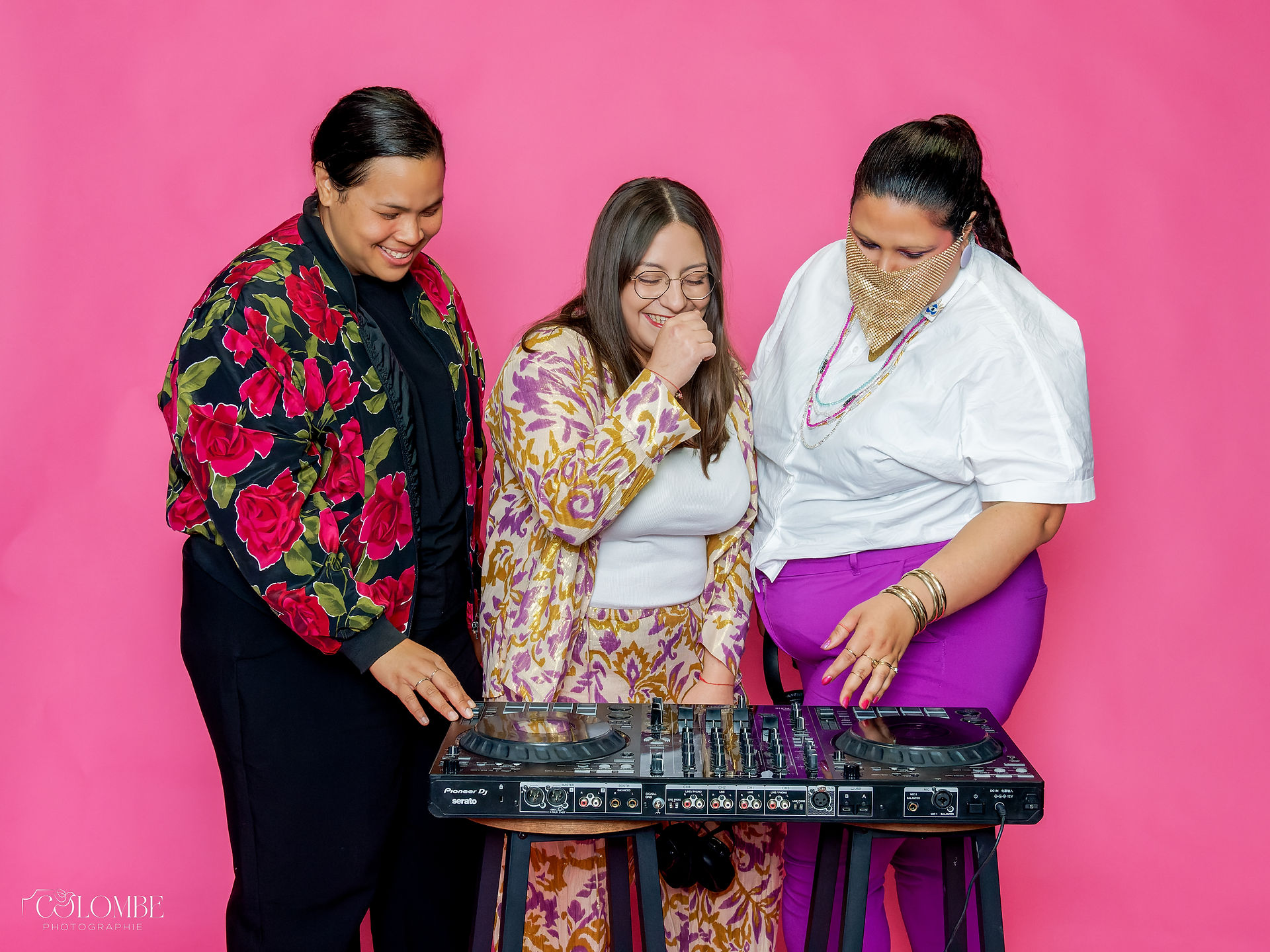 Image utilisée comme post de remerciement sur Instagram à l’issue de la soirée DJ 100% queers et raciséEs organisée par Les FlamboyantEs. La photo montre les trois DJ rassemblées en studio dans une ambiance détendue et festive, devant un fond rose vif : DJ Koré Kará à gauche, DJ Joya au centre, et DJ Mawa Bouh à droite. Toutes trois interagissent autour des platines dans un moment de complicité joyeuse. Ce visuel clôture la communication visuelle de l’événement et reflète l’univers inclusif, coloré et engagé de la soirée. Il a été réalisé à Gentilly dans le cadre d’un shooting conçu pour alimenter les réseaux sociaux d’un collectif queer, en collaboration avec une photographe événementiel queer en région parisienne.