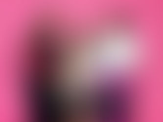 Photo de groupe joyeuse et colorée prise après la soirée DJ organisée par Les FlamboyantEs, mettant en scène les trois artistes queer et racisées derrière une table de mixage Pioneer DJ. À gauche, DJ Koré Kará sourit en regardant vers l’avant, au centre DJ Joya rit en couvrant sa bouche, et à droite DJ Mawa Bouh en tenue blanche et violette désigne les platines avec complicité. L’arrière-plan rose vif donne une ambiance pop et festive à ce portrait collectif. Cette photo de remerciement, prise en studio à Gentilly, illustre le travail d’une photographe événementiel queer en région parisienne, spécialisée dans la valorisation des artistes LGBTQIA+ racisé·es et des événements communautaires engagés.