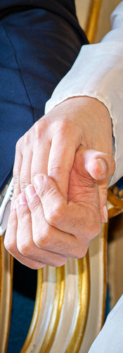 Détail des mains d’Annapaola et Angelo se tenant tendrement pendant leur mariage civil à la mairie du 7e arrondissement de Paris. La photo en couleur met en valeur l’émotion et la douceur du moment, entre la robe satinée de la mariée et le costume élégant du marié. Un cliché intime et symbolique capturé par Colombe Photographie, photographe de mariage civil à Paris et en région parisienne.
