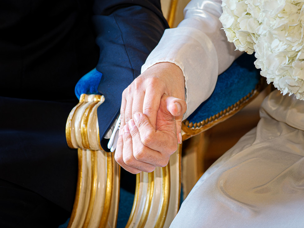 Détail des mains d’Annapaola et Angelo se tenant tendrement pendant leur mariage civil à la mairie du 7e arrondissement de Paris. La photo en couleur met en valeur l’émotion et la douceur du moment, entre la robe satinée de la mariée et le costume élégant du marié. Un cliché intime et symbolique capturé par Colombe Photographie, photographe de mariage civil à Paris et en région parisienne.