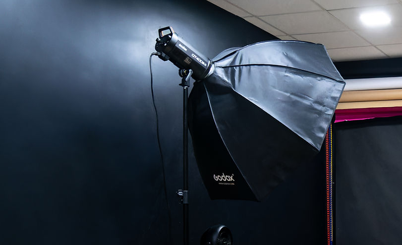 Photo studio for rent in Gentilly with black background, GODOX flash, light wood flooring and accessory shelves, ideal for professional photo shoots near Paris.