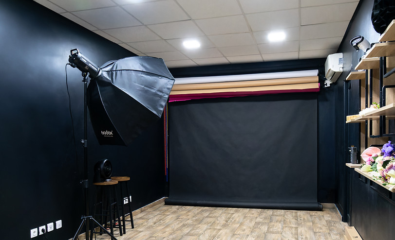 Photo studio for rent in Gentilly with black background, GODOX flash, light wood flooring and accessory shelves, ideal for professional photo shoots near Paris.