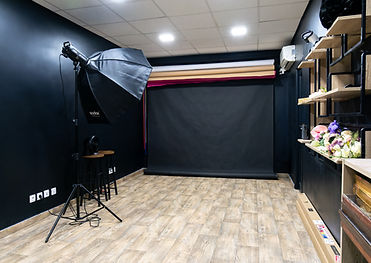 Photo studio for rent in Gentilly with black background, GODOX flash, light wood flooring and accessory shelves, ideal for professional photo shoots near Paris.