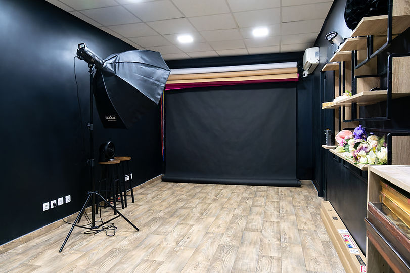 Photo studio for rent in Gentilly with black background, GODOX flash, light wood flooring and accessory shelves, ideal for professional photo shoots near Paris.