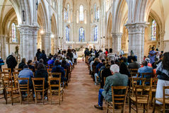 Vue d’ensemble de l’assemblée réunie pour la première communion de Francesco, capturée dans une église lumineuse de la région parisienne. Familles et proches se recueillent pendant la messe, entre vitraux colorés et colonnes de pierre. Cette photo met en valeur l’atmosphère solennelle et chaleureuse d’une cérémonie chrétienne, documentée par Colombe Photographie, photographe professionnelle basée à Gentilly et spécialisée dans les communions, baptêmes et événements religieux en Île-de-France.