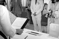 Photo prise durant la cérémonie du mariage civil de Nathanaël et Hafsa à la mairie de Massy. On y voit l’élu·e lisant les articles du Code civil, avec les mariés debout face à elle, bouquet à la main. Ce moment marque le passage symbolique et juridique à la vie de couple. Reportage réalisé par Colombe Photographie, photographe de mariage civil à Gentilly et en Île-de-France.